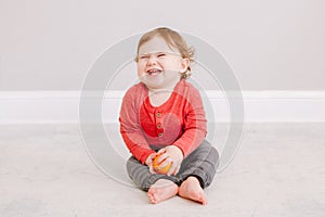 Cute adorable Caucasian baby boy eating citrus fruit. Finny child eating healthy organic snack. Solid finger supplementary food