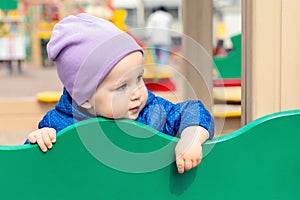 Cute adorable caucasian toddler boy enjoy having fun at outdoor playground. Portrait of happy little child playing ouside