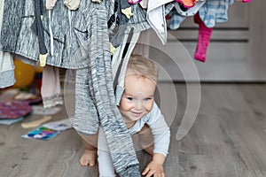 Cute adorable caucasian toodler boy laughing and having fun playing home with mess and clothes dryer on background