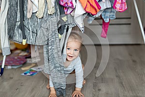 Cute adorable caucasian toodler boy laughing and having fun playing home with mess and clothes dryer on background