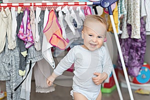 Cute adorable caucasian toodler boy laughing and having fun playing home with mess and clothes dryer on background. portrait of