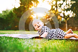 Cute adorable child baby boy lying on the grass on nature