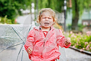 Cute adorable crying sad toddler girl on a walk. Little baby child going for walk with parents. frustrated healthy kid