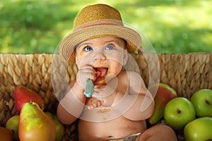 Cute adorable infant funny dirty baby trying to eat himself with fruit or vegetable puree smeared on his face. Baby