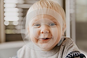 Cute Adorable Little Blonde Toddler Kid Laughing, Having Fun, and Making Silly Faces Outside at Home on the Patio Screened Porch