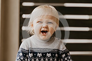 Cute Adorable Little Blonde Toddler Kid Laughing, Having Fun, and Making Silly Faces Outside at Home on the Patio Screened Porch