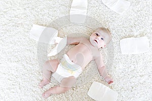 Cute adorable newborn baby of 3 moths with diapers. Hapy tiny little girl or boy looking at the camera. Dry and healthy