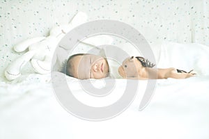 Cute adorable newborn baby boy wrapped or swaddle in a blanket, sleeping in bed
