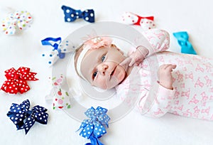 Cute adorable newborn baby child with colorful bows