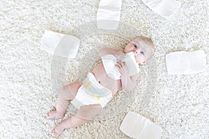 Cute adorable newborn baby of 3 moths with diapers. Hapy tiny little girl or boy looking at the camera. Dry and healthy photo