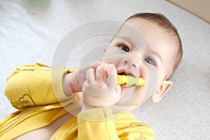 Cute adorable newborn baby playing with colorful rattle toy. baby with teether. six months old lovely baby portrait on