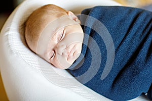 Cute little newborn baby girl sleeping wrapped in blanket