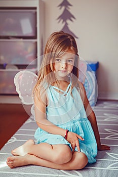 Cute adorable pretty dressed preschool girl playing a fairy princess at home. Child creativity imagination and fantasy dreams