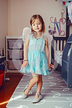 Cute adorable pretty dressed preschool girl playing a fairy princess at home. Child creativity imagination and fantasy dreams