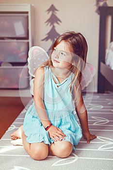 Cute adorable pretty dressed preschool girl playing fairy princess at home. Child creativity imagination and fantasy dreams