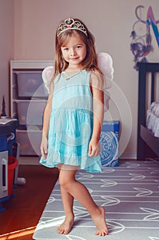 Cute adorable pretty dressed preschool girl playing fairy princess at home. Child creativity imagination and fantasy dreams