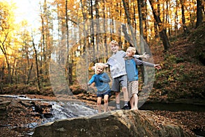 Cute, Adventurous Children in Autumn Woods by Waterfall