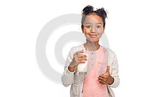 cute african american child drinking milk and showing thumb up