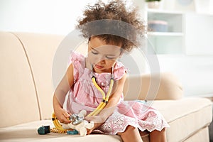 Cute African American child imagining herself as doctor