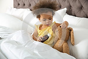 Cute African American child imagining herself as doctor while playing with toy bunny