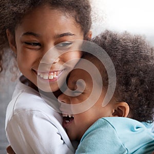 Cute african american kids with funny faces hugging laughing, cl