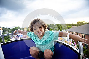 A cute African American little boy enjoying a Ferris Wheel ride at a local carnival