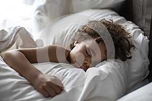 Cute African American little boy sleeping soundly in his nice warm bed photo