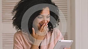 Cute african american woman browses content or communicates on social networks using digital tablet. Black female posing
