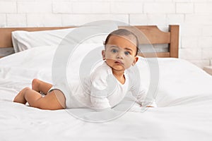 Cute African Baby Lying On Stomach Posing In Bedroom Indoors