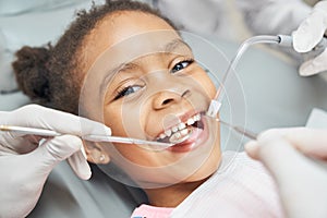 Cute african girl during dental treatment at modern clinic