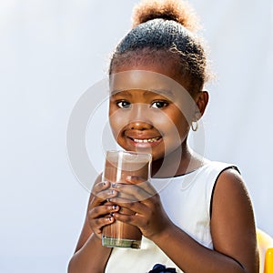 Cute african girl with milk chocolate drink.