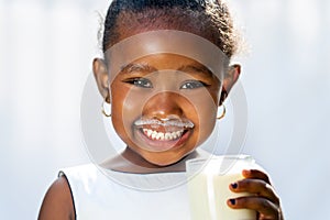 Cute african girl showing white milk mustache.