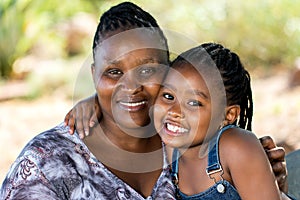 Cute african mother and child embracing outdoors.