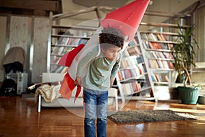 Cute afro american boy playing with paper rocket