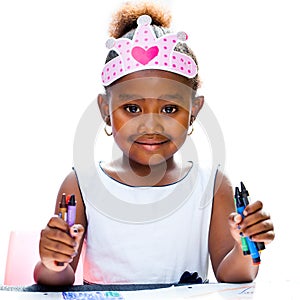 Cute afro girl holding wax crayons.