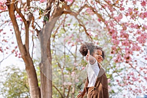 A cute Afro girls under flowering tree in park.