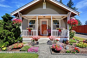 Cute American house exterior with covered porch and flower pots