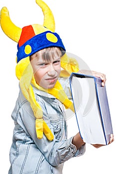 Cute angry blond boy in a stylish shirt holding a very big blue book looking dangerous