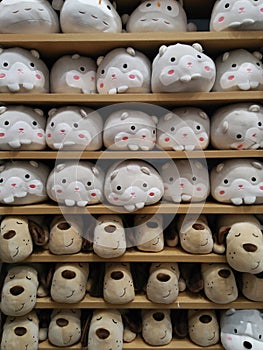 Cute animal dolls on orderly shelves in gift shop background