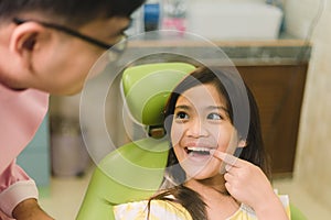 Cute Asain girl during dental treatment at modern clinic