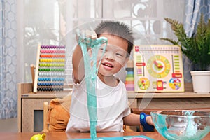 Cute  Asian 4 years old boy having fun making fluffy slime, Young kid having fun playing and being creative by science experiment