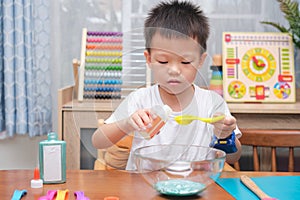 Cute  Asian 4 years old boy having fun making fluffy slime, Young kid having fun playing and being creative by science experiment