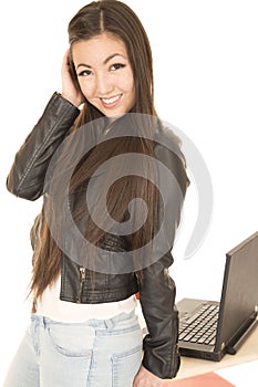 Cute Asian American teen girl by her computer posing