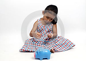Cute asian baby girl sitting and blue piggy bank on white backgrounds for Business and finance
