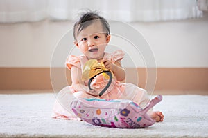 Cute asian baby girl sitting in the living room and smiling while playing with parent