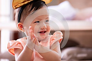 Cute asian baby girl smiling and clap her hand while playing with her parent
