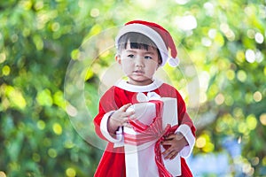 Cute asian baby girl wearing santa suit holding beautiful gift box in hand