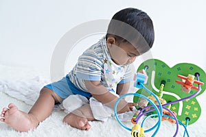 Cute asian baby sitting and play wooden toys
