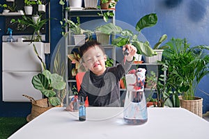 Cute Asian boy child having fun making easy science experiment