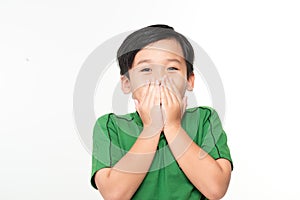 Cute asian boy covers his mouth with his hands